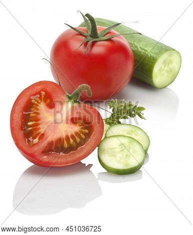 Two Cherry Tomatoes, One Mini Cucumber And Oregano Leaves On A White Background