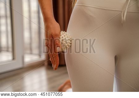 Athletic Slim Caucasian Woman Doing Thigh Self-massage With A Massage Ball Indoors. Self-isolating M