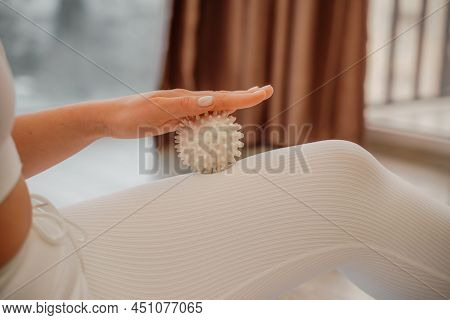 Athletic Slim Caucasian Woman Doing Thigh Self-massage With A Massage Ball Indoors. Self-isolating M