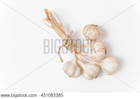A Bunch Of Five Garlic Tied With Twine On A White Background. Close Up Top View.