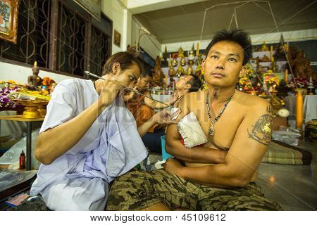 NAKHON CHAI, Tajlandia - MAR 23: Niezidentyfikowane mnich sprawia, że tradycyjne Yantra tatuażu w Wai pełna