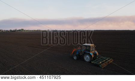 Farming: A Farmer On A Tractor Works The Field Before Sowing