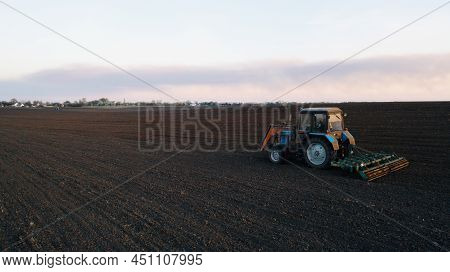 Farming: A Farmer On A Tractor Works The Field Before Sowing