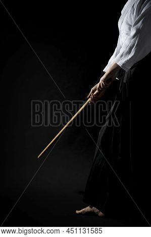 A Girl In Black Hakama Standing In Fighting Pose With Wooden Sword Bokken Over Dark Background. Shal