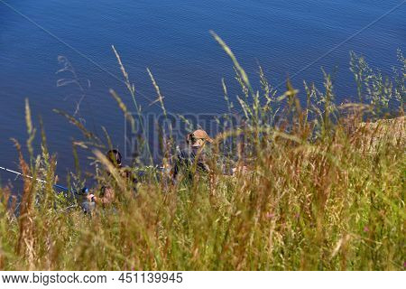 Two Women Fish On The Banks Of Lake Claiborne.  They Are Hidden By The Bank And Tall Grasses In Thei