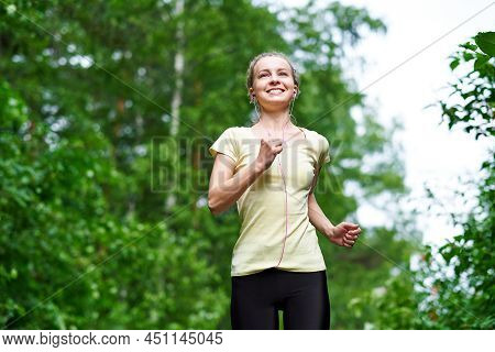 Running Woman Atletic Spotsman Trains In The Summer Park. Outdoor Fitness Portrait After Rain