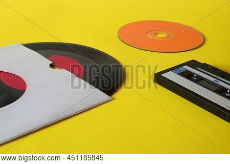 Musical Storage Devices And Copy Space. Old Audio Cassette Tapes, Compact Disc And Vinyl Record On Y