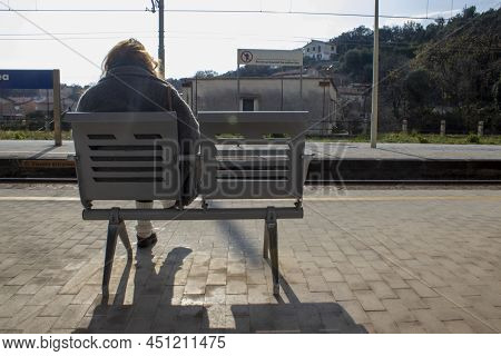 The Girl Is Sitting On A Bench At The Railway Station Waiting For The Train. Back View. The
Concept 