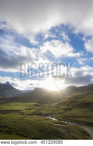 Sunset In A Mountain Landscape With Meadows Where Hikers Walk And A Few Cows Graze, Laruns, France, 