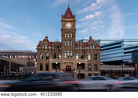 Calgary, Alberta - March 13, 2021: Cars Cruising Past Calgary's Historic City Hall In The Evening.