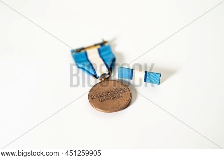 Shallow Focus Shot Of The Back Of A United Nations Peacekeeper's Medal And Service Ribbon On A White