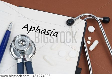 Medicine And Health Concept. On A Brown Surface Lie Pills, A Pen, A Stethoscope And A Notebook With 