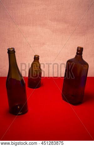 Still Life With Tilted Bottles On A Red Table