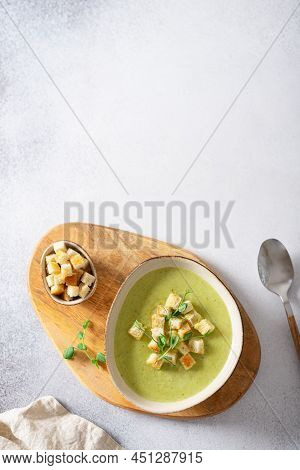 Bowl Of Broccoli Cream Soup With Parmesan Cheese, Crunchy Croutons And Microgreen On A Wooden Tray,