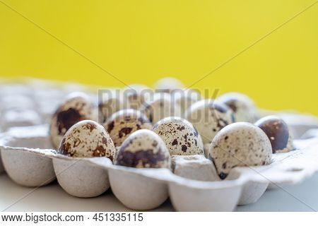 Spotted Quail Eggs In An Egg Box On A Yellow Background, Natural Eco Friendly Products.