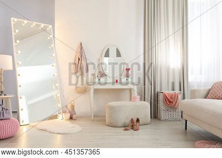 Large Mirror With Light Bulbs And Dressing Table In Stylish Room. Interior Design