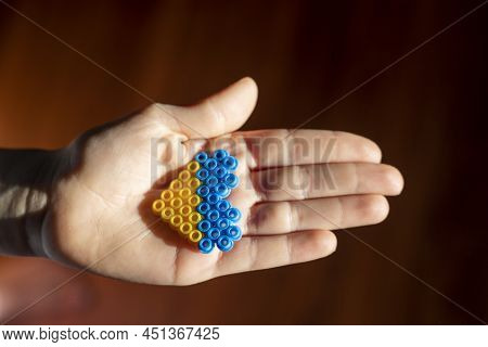 Small Children's Hand Holds In The Palm Of The Hand The Flag Of Ukraine In The Form Of A Heart In A 