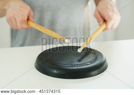 Close Up Of Young Drummer Holding Drum Sticks And Practicing On A Black Drum Pad.