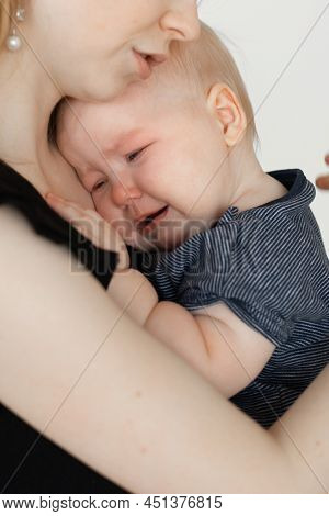 Face Of Crying Child. Mother Caring, Holding Wailing Depressed Baby In Arms. Temperature, Illness, K