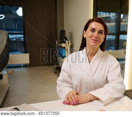 Beautiful European Middle Aged Woman In White Terry Bathrobe At Medical Appointment In Cosmetologica