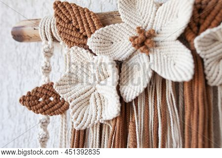 Handmade Macrame Wallhanging. 100% Cotton Wall Decoration With Wooden Stick Hanging On A White Wall.