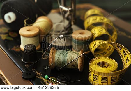 Old Retro Tailor's Tools For Sewing Clothes. Centimeter, Scissors, Thimble And Needle With Snitch.