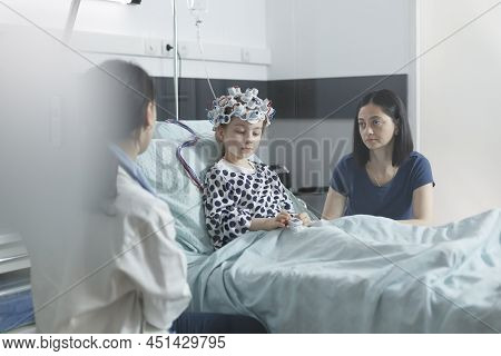Hospital Pediatric Specialist Checking Eeg Scan Results Of Sick Child While In Pediatric Ward Recove