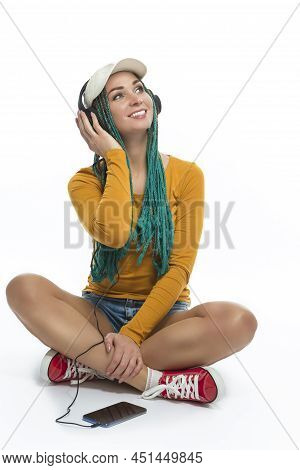 Young Winsome Positive Caucasian Female With African American Dreadlocks Listens Music In Wirreless