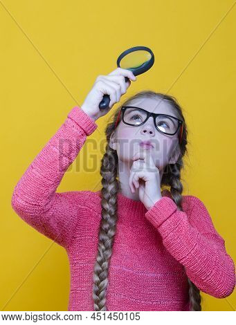 Portrait Of Smiling Caucasian Girl In Santa Hat And Red Scarf Holding Empty Big Magnifyingglass Whil
