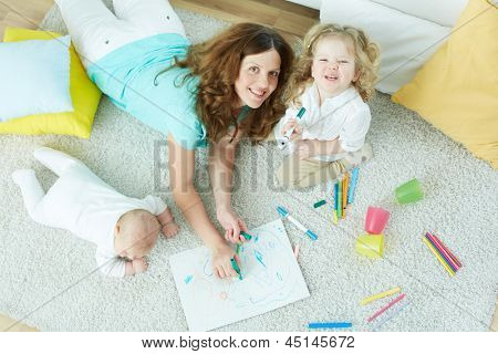 The above-view portrait of a beautiful babysitter looking after cute kids