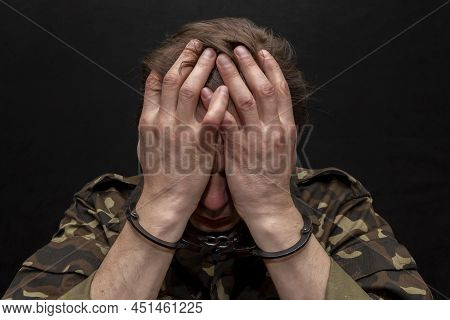 A Military Soldier Or Officer In Handcuffs On A Dark Background. War Criminal, Criminal Liability Of