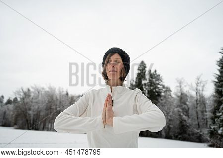 Young Woman Meditating With Her Palms Joined Infront Of Her Chest Standing Outside In Snowy Winter N