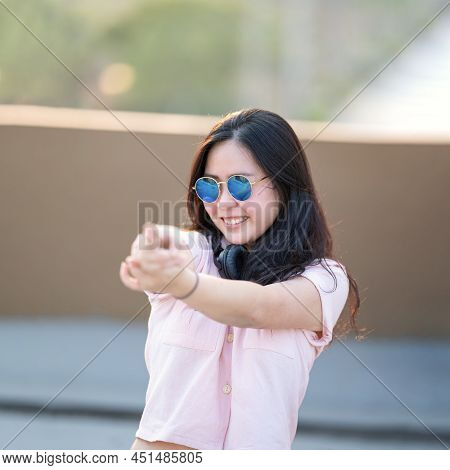 Asian Woman In The Pink Shirt Is Playing Finger Gun, Aim And Focus On It. She Relaxes And Smiles Bet
