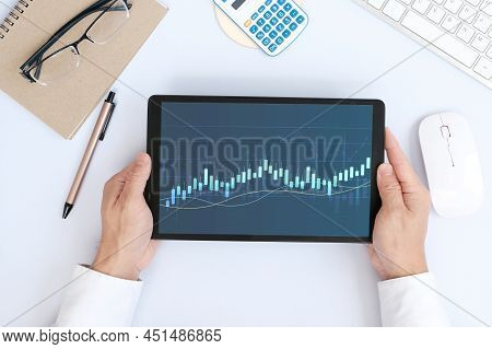Hand Using Tablet And Analysing Banking And Investment Growth Graph To Develop Smart Financial Decis
