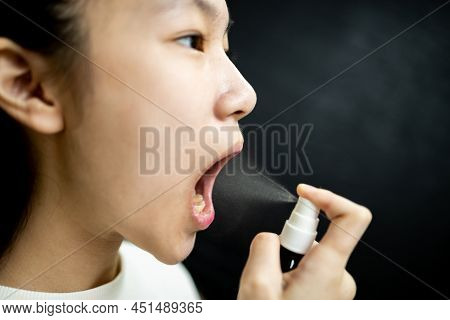 Asian Child Girl Spraying Medicine,treatment For Pain In Oral,sore Throat With Cold,flu,protect Agai