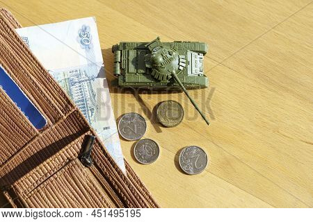 War In Ukraine And Sanctions Against Russia Concept. Wallet With Russian Rubles And A Toy Tank On A 