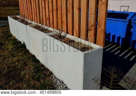 Wooden Fencing At The Place For Sorting Municipal Waste. Natural Plank Fence Is Complemented By Conc