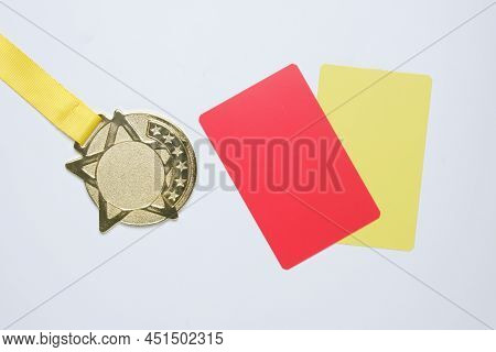 A Picture Of Gold Medal With Red And Yellow Card. Sports Disqualification Concept.