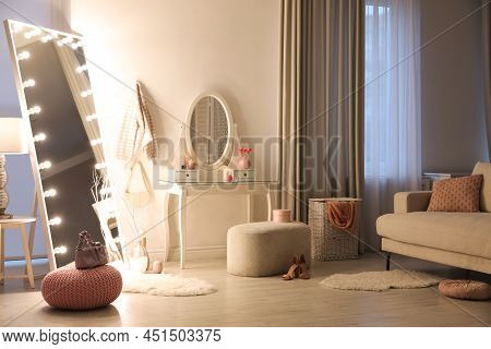 Large Mirror With Light Bulbs And Dressing Table In Stylish Room. Interior Design