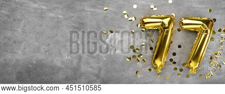 Yellow Foil Balloon Number, Number Seventy Seven On A Concrete Background. Greeting Card With The In