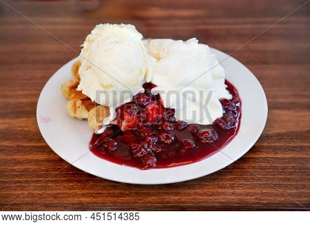 A Hot Waffle With Cherries, Ice Cream And Whipped Cream.