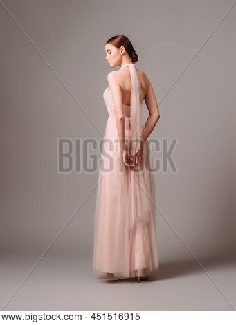 Elegant Moscato Dress With Bow. Beautiful Pink Chiffon Evening Gown. Studio Portrait Of Young Brunet