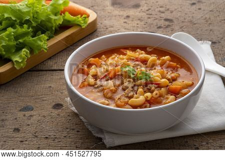 Beef And Tomato Macaroni Soup In White Bowl On Wood Table