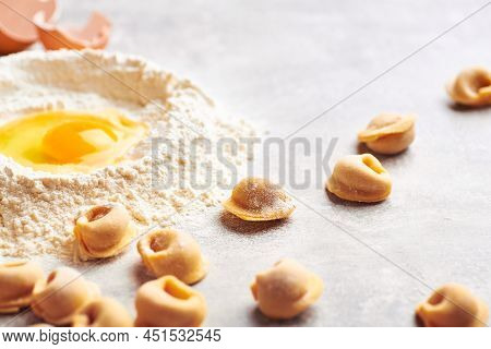 Fresh homemade tortellini pasta. Uncooked homemade tortellini pasta making. Fresh pasta. Making fresh ravioli pasta. Ravioli homemade pasta. Making pasta ravioli with egg. Ravioli pasta.