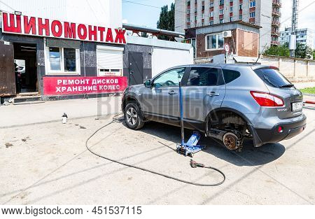 Samara, Russia - July 4, 2021: Сar At The Tire Mounting With Removed Wheel On Pneumatic Jack. Season
