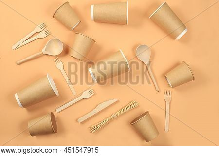 A Set Of Environmentally Friendly Appliances On A Pastel Table. Kraft Paper Coffee Cups, Wooden Fork