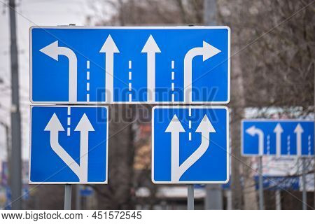 Traffic Sign Pointing Multiple Road Lanes Direction On City Street. Signboard Arrows For Urban Trans