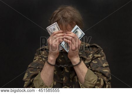 A Military Soldier Or Officer In Handcuffs Holds Bundles Of Dollar Bills In His Hands, Selective Foc