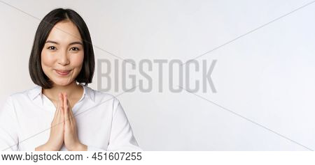 Close Up Portrait Of Young Japanese Woman Showing Namaste, Thank You Arigatou Gesture, Standing Over