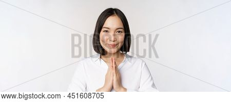 Close Up Portrait Of Young Japanese Woman Showing Namaste, Thank You Arigatou Gesture, Standing Over